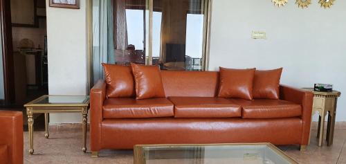 a brown leather couch sitting in a living room at Cozy Cottage at Afgan Lodge in Murree