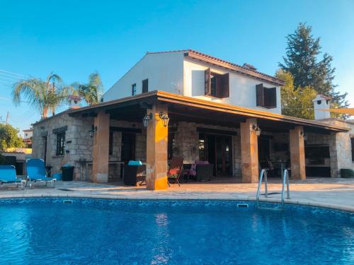 ein Haus mit einem Swimmingpool vor einem Haus in der Unterkunft Koutsini Villa in Pano Akourdalia
