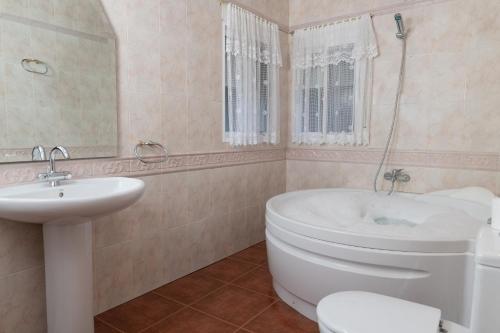 a bathroom with a tub and a toilet and a sink at Casa Rural Doña Josefa in Cilanco