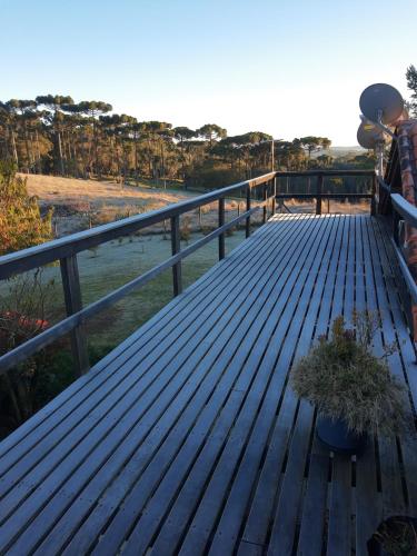 a wooden deck with a potted plant on it at CHÁCARA QUEDINHA D'ÁGUA in Campo Alegre