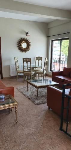 a living room with a couch and a table and chairs at Cozy Cottage at Afgan Lodge in Murree