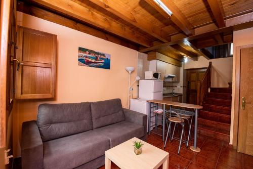 a living room with a couch and a kitchen at Casa Mariví in Niembro