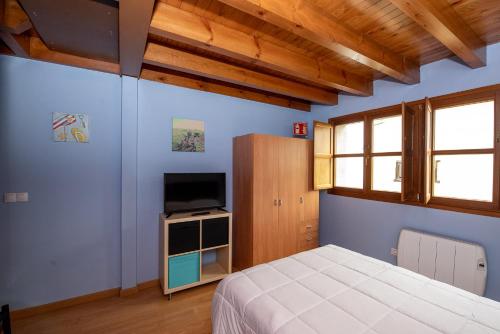 um quarto com uma cama e uma televisão de ecrã plano em Casa Mariví em Niembro