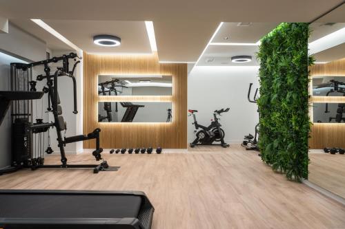 een fitnessruimte met fitnessapparatuur en een groene muur bij LUX&EASY Athens Downtown Apartments in Athene