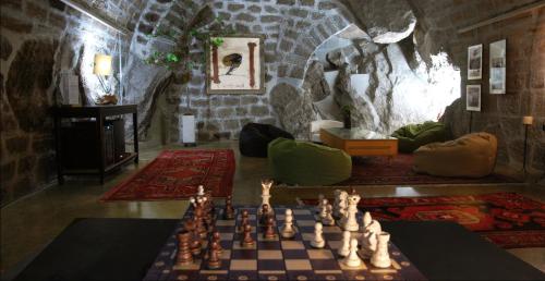 a room with a chess board and a room with a stone wall at Appartement ciel de fugeres in Le Puy-en-Velay