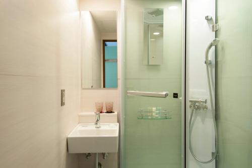 a white bathroom with a sink and a shower at Agora Place Tokyo Asakusa in Tokyo