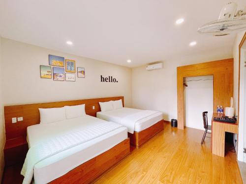 a room with two beds and a sign that says hello at Ninh Binh The View Point Home & Spa in Ninh Binh