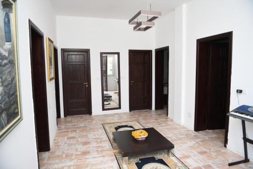 Una sala de estar con una mesa y algunas puertas. en Hotel Vila C plus plus, en Berat