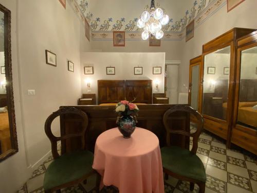 a room with a table with a vase of flowers on it at Antico Palazzo Spinola in Gallipoli