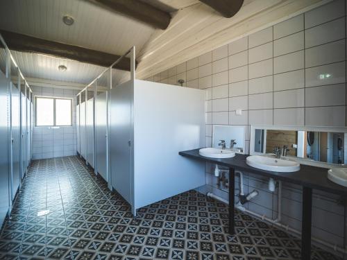 a bathroom with two sinks and two mirrors at Metsaluige Turismitalu in Kabli