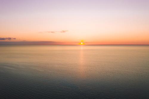a sunset over the water with the sun setting at Metsaluige Turismitalu in Kabli