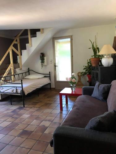 un salon avec un lit et un canapé dans l'établissement La Bastide, au cœur de la Provence, à Sainte-Anastasie-sur-Issole