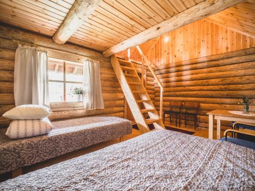 a bedroom with two beds in a log cabin at Metsaluige Turismitalu in Kabli