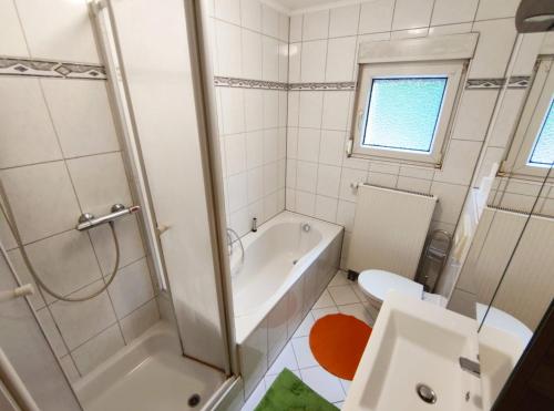 La salle de bains est pourvue d'une baignoire, de toilettes et d'un lavabo. dans l'établissement Ferienhaus Gonsbach, à Mayence