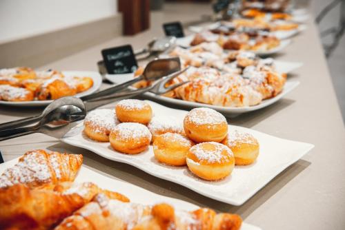 a bunch of donuts on plates on a table at Hotel Bel Soggiorno in Malosco