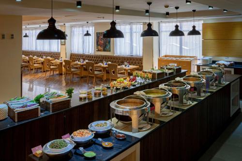 a buffet line with plates of food in a restaurant at Ramada Addis, Addis Ababa in Addis Ababa