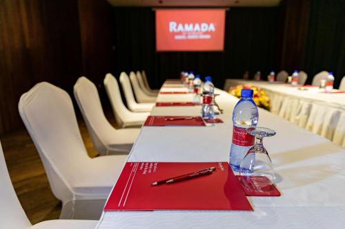a row of tables in a room with white chairs at Ramada Addis, Addis Ababa in Addis Ababa