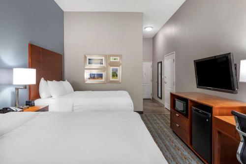 a hotel room with a bed and a flat screen tv at Comfort Inn & Suites in Cleveland