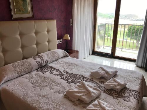 ein Schlafzimmer mit einem Bett mit Handtüchern darauf in der Unterkunft Apartamentos Gala in Noja