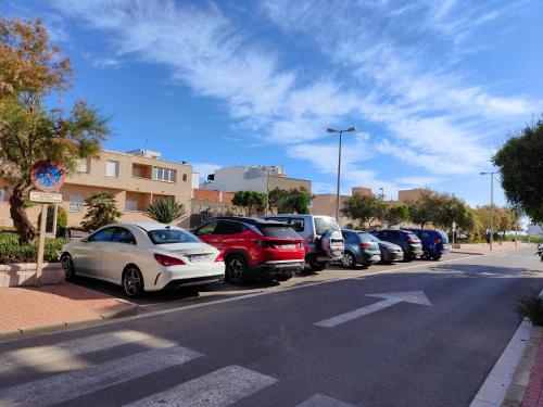 una fila de autos estacionados en un estacionamiento en Hostal Las Dunas en Cabo de Gata