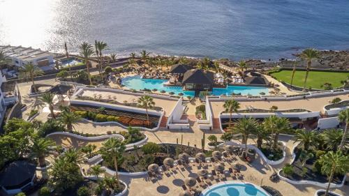 a beach filled with lots of palm trees at Secrets Lanzarote Resort & Spa - Adults Only (+18) in Puerto Calero