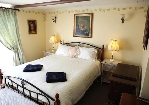 a bedroom with a bed with two bags on it at Ayers Burra - Historical 1851 Cottage in Burra