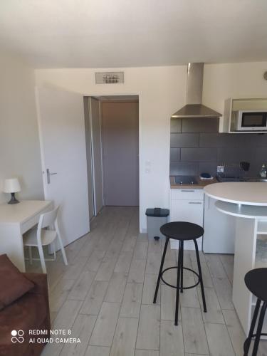 une cuisine avec une table et des chaises dans une pièce dans l'établissement Charmant studio avec piscine et clim (en été), à Aix-en-Provence