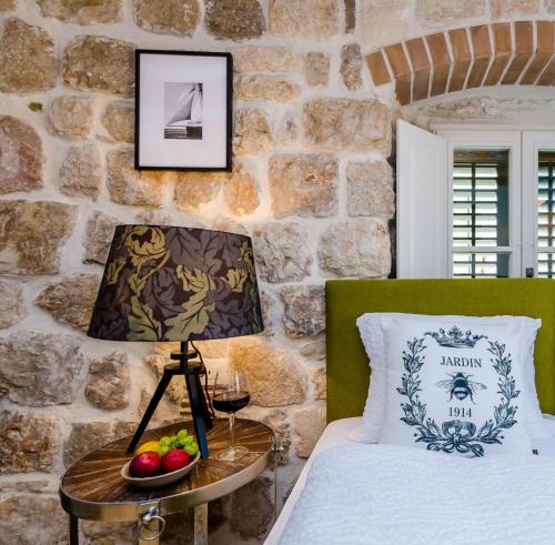 een slaapkamer met een bed en een tafel met een lamp bij Villa Monte Santo in Dubrovnik