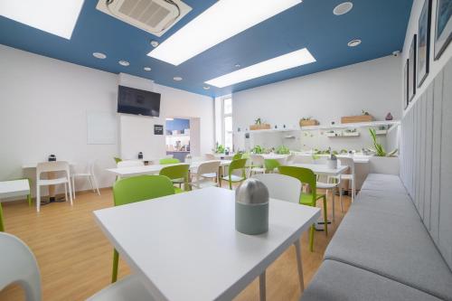 a dining room with white tables and green chairs at Hotel Traffic Wrocław Stare Miasto in Wrocław