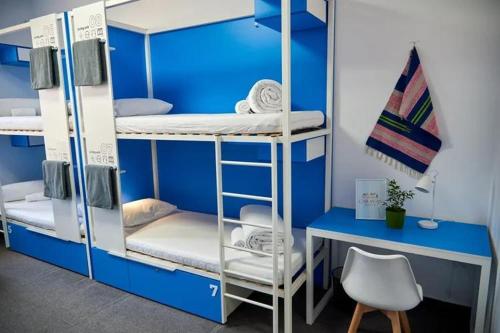 TürkistanにあるCaravanの二段ベッド、デスク、椅子が備わる客室です。