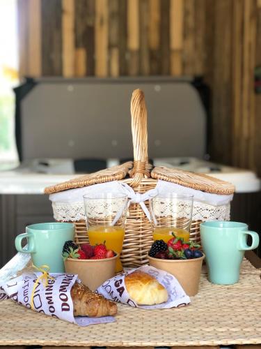 een picknickmand met ontbijtproducten en drankjes op een tafel bij Casitas de Madera O Loureiro in Noya