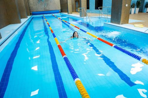 a woman is swimming in a swimming pool at Hotel France in Vinnytsya
