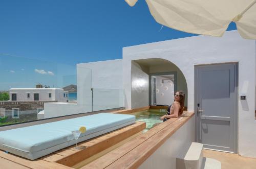 a woman sitting in a swimming pool in a house at Argo Boutique Hotel in Naxos Chora