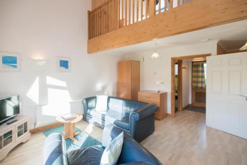 a living room with a couch and a television at Tregenna Castle Resort in St Ives