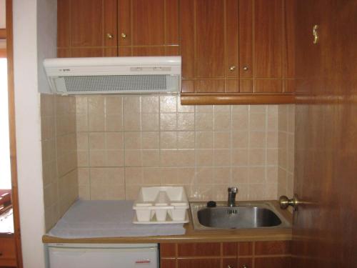 a kitchen with a sink and a microwave at Marialena Pension in Ireon