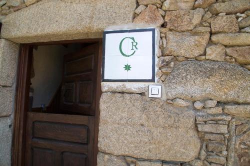 um sinal numa parede de pedra ao lado de uma porta em CASA DE PIEDRA em Casas del Monte