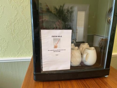 a display case with a bunch of white vases at Beechwood Ensuite Guest House in Ayr