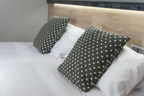 two black pillows sitting on a bed with white pillows at Alda Centro Pamplona in Pamplona