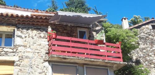 a red bench on the side of a building at Gîtes chez Daniel "Cevennes 2" in Mars