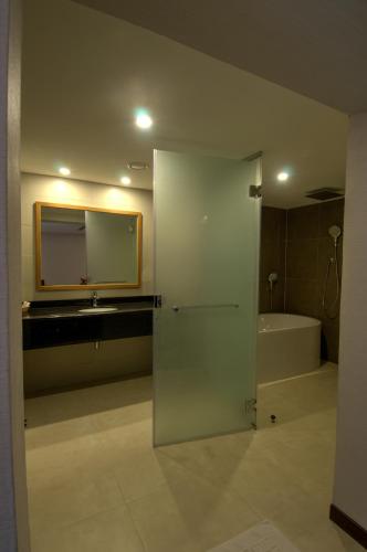 a bathroom with a mirror and a sink and a tub at Ramee Dream Resort in Seeb