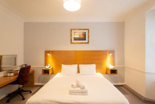 a bedroom with a bed with two towels on it at Tregenna Castle Resort in St Ives