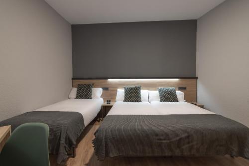 a room with two beds in a room at Alda Centro Pamplona in Pamplona