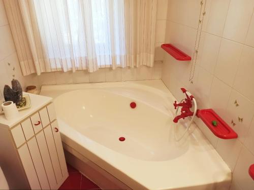 łazienka z białą wanną z czerwonym kranem w obiekcie casa mauro w Aoście