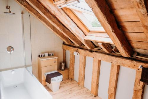 a bathroom with a white toilet and a window at Creeksea Place Barns in Burnham on Crouch