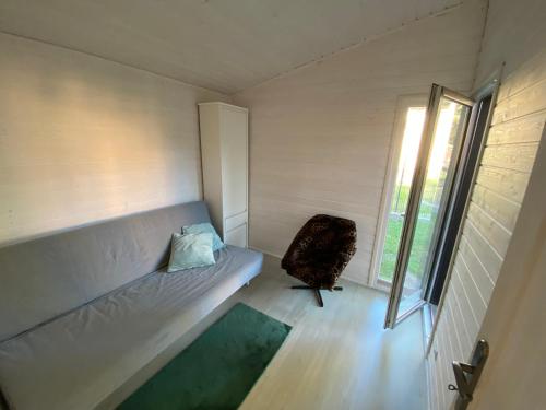 Habitación pequeña con sofá y silla. en Domek letniskowy Dębki, blisko morza :), en Dębki
