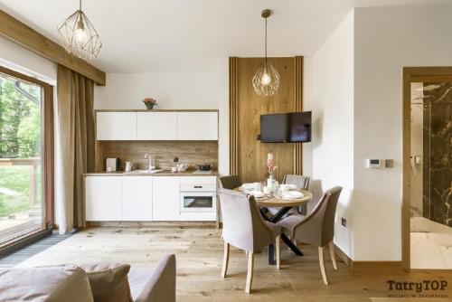 a kitchen and dining room with a table and chairs at Tatra Resort & SPA in Kościelisko