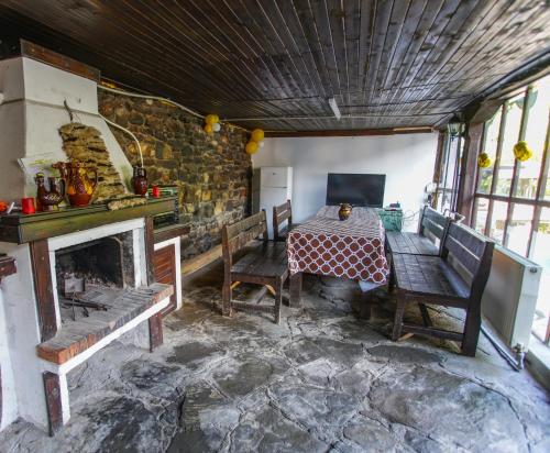 BalkanetsにあるGuest House Planinska Sreshtaのテーブルと椅子、暖炉が備わる客室です。