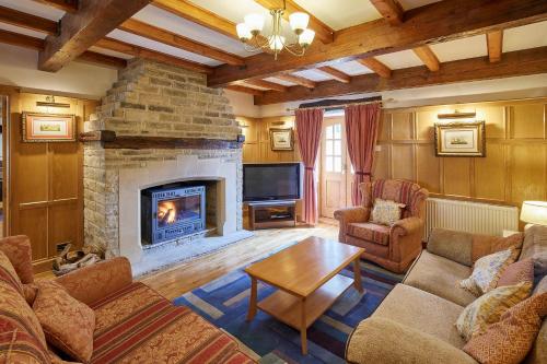 sala de estar con chimenea y TV en Host & Stay - The Cottage Barn, en Skipton
