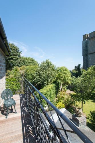 a balcony with a bench on a wooden deck at Tregenna Castle Resort in St Ives