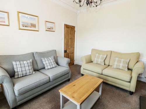 a living room with two couches and a coffee table at Min Y Don in Colwyn Bay